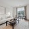 Living room in a Motif apartment home with a couch, table, and large NYC windows.