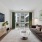 Apartment on the ground floor with a couch, table, TV, and large windows.